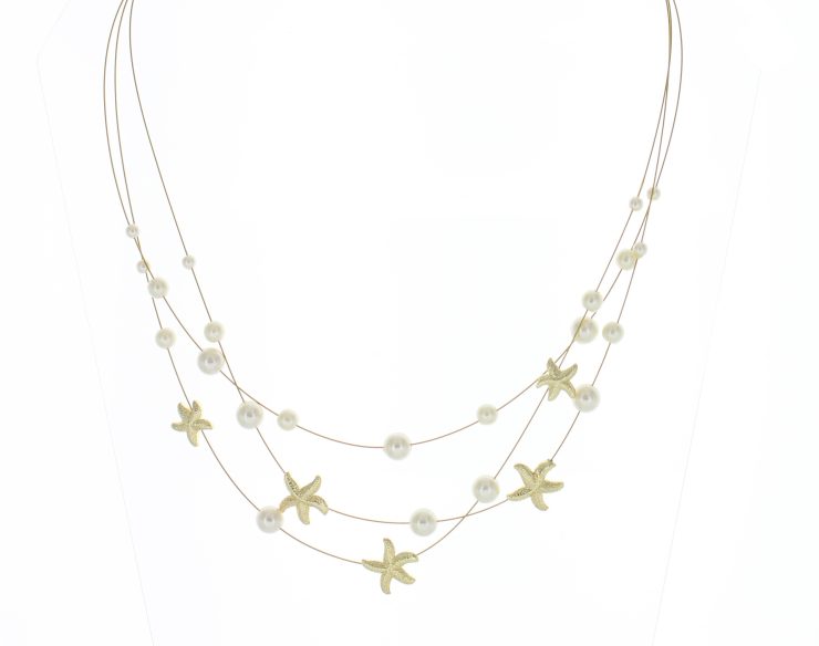 A photo of the Gold Starfish and Pearls Necklace product