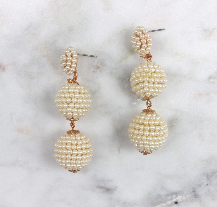 A photo of the Shimmer Thread Wrap Ball Earrings product