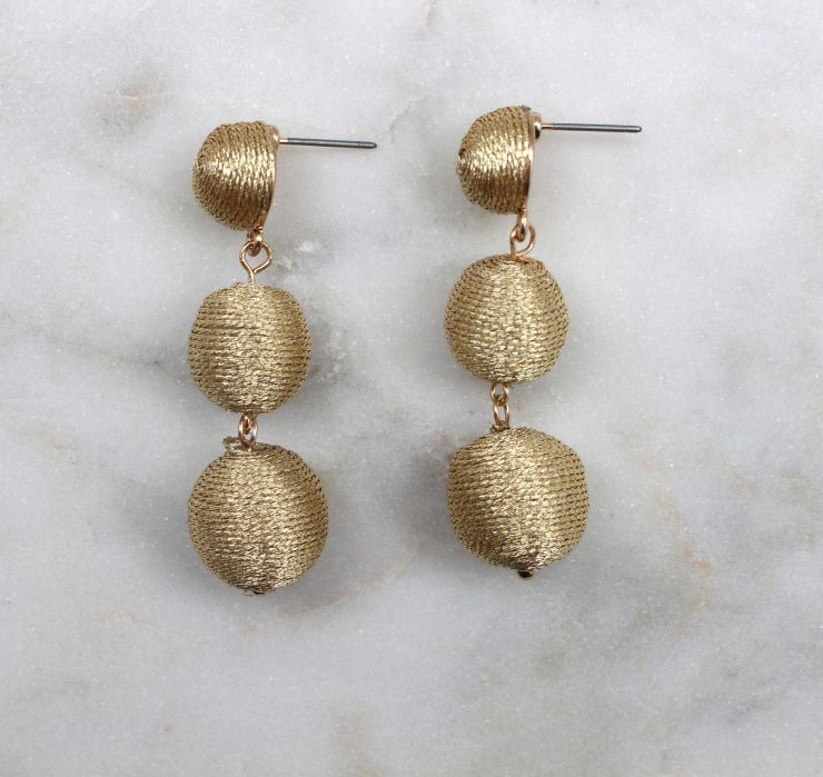 A photo of the Shimmer Thread Wrap Ball Earrings product