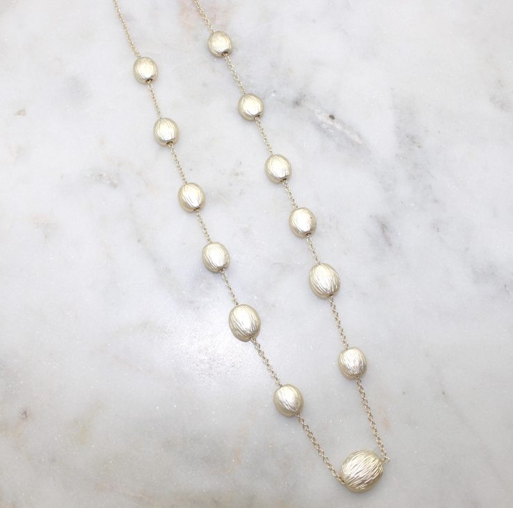 A photo of the Matte Gold Beaded Necklace product