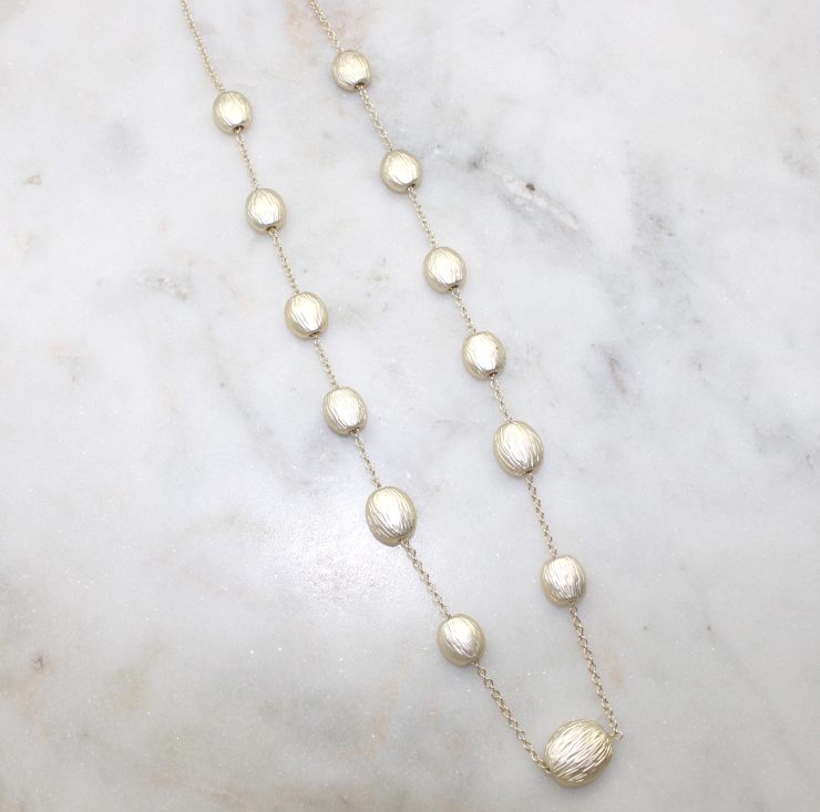 A photo of the Matte Gold Beaded Necklace product