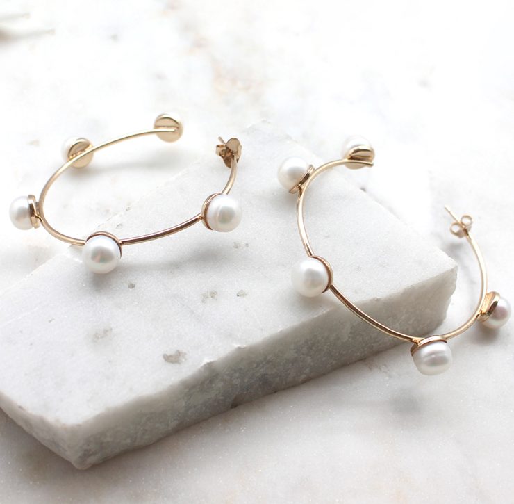 A photo of the Glimmer Hoop Earrings product