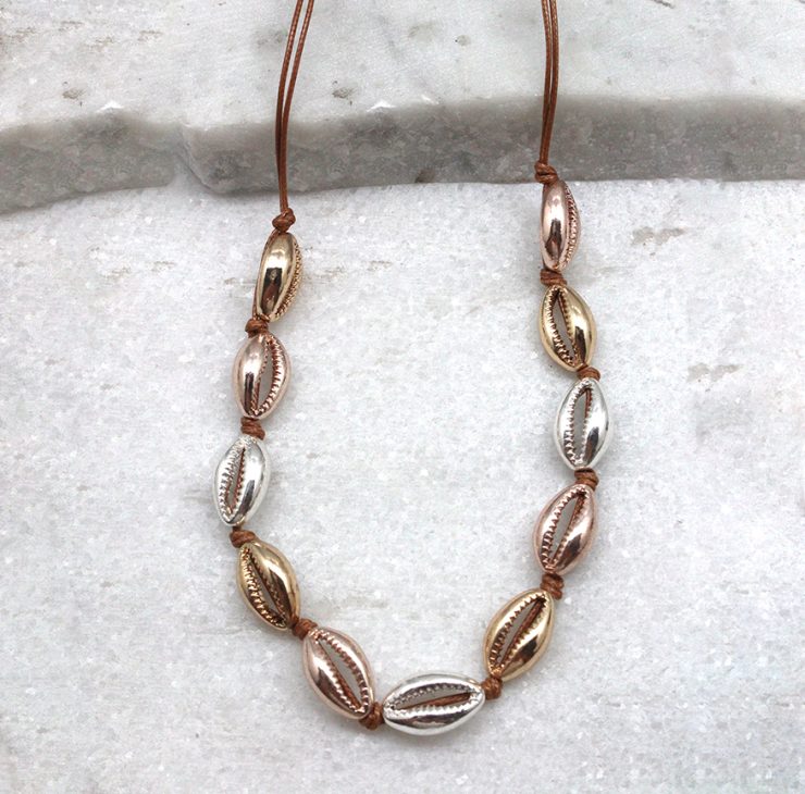 A photo of the Cowrie Knotted Necklace in Three Tone product
