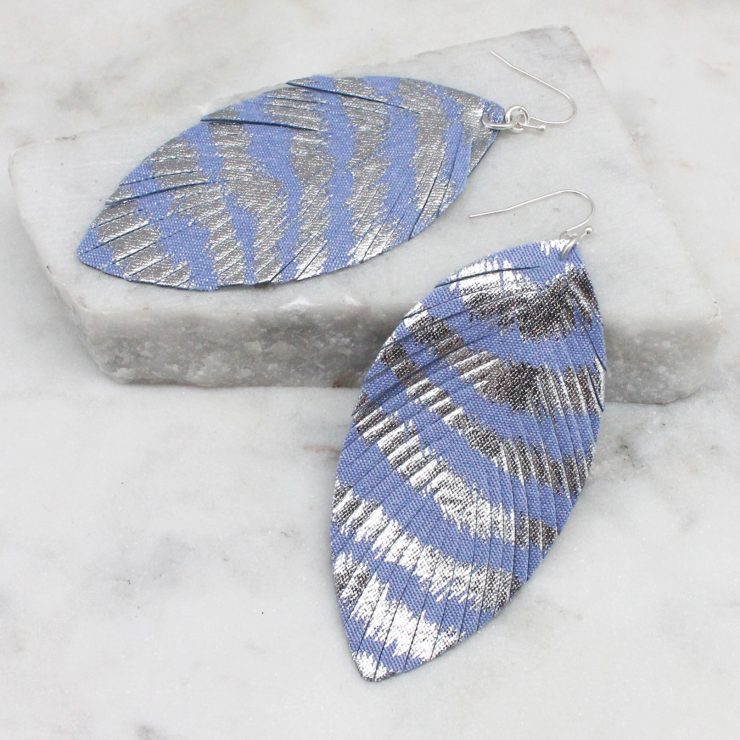 A photo of the Metallic Stripe Feather Earrings In Lilac product