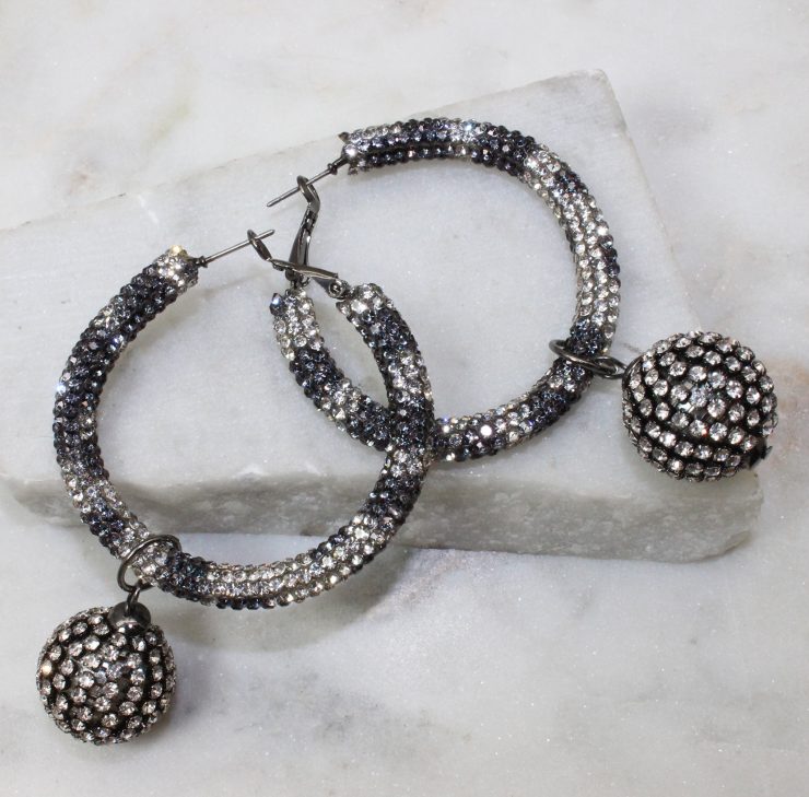 A photo of the Disco Hoop Earrings In Black & Clear product