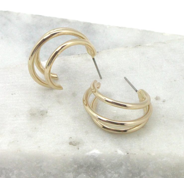 A photo of the Triple Threat Round Hoop Earrings product