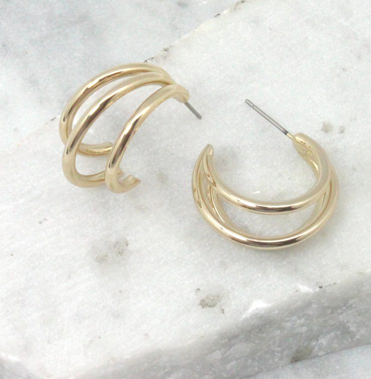 A photo of the Triple Threat Round Hoop Earrings product