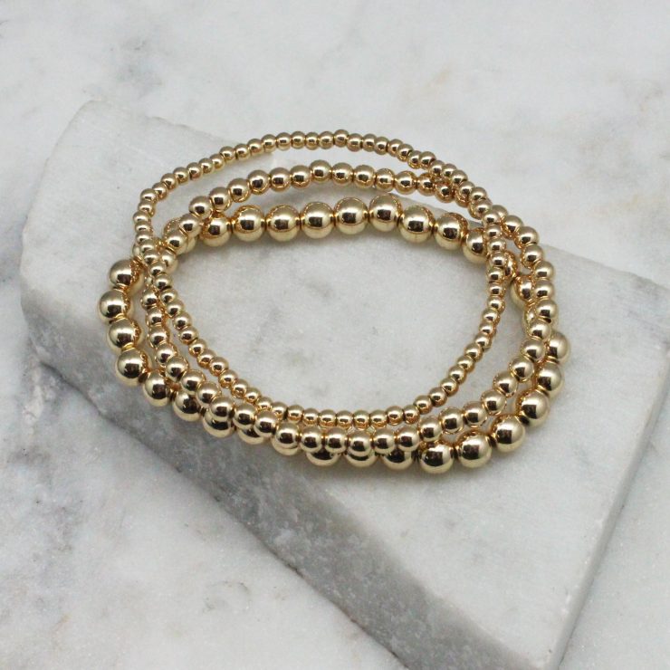 A photo of the Gold Beaded Stackable Bracelets – Set of 3 product