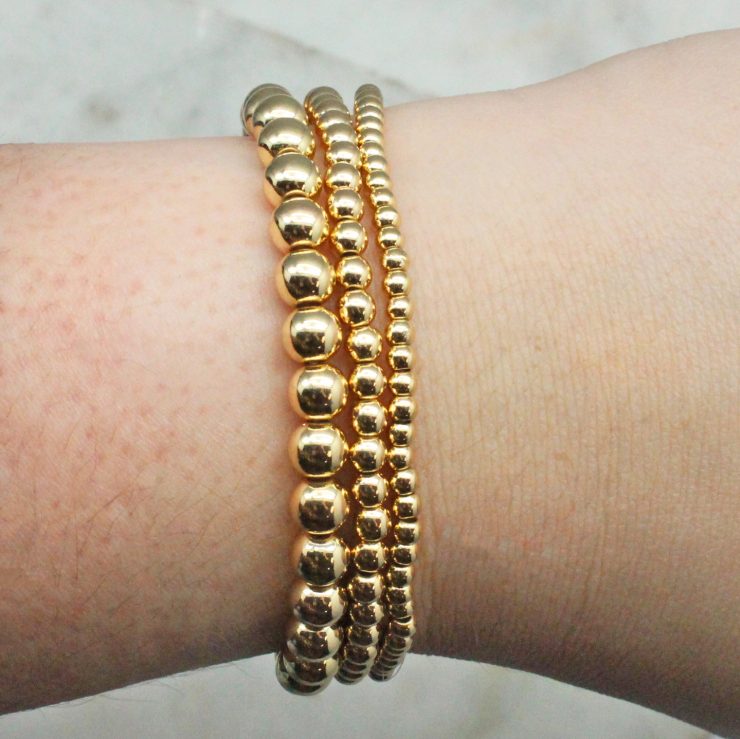 A photo of the Gold Beaded Stackable Bracelets – Set of 3 product