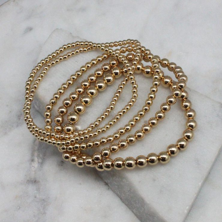 A photo of the Gold Beaded Stackable Bracelets - Set of 5 product