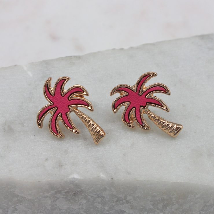 A photo of the Crescent Palm Earrings In Pink product