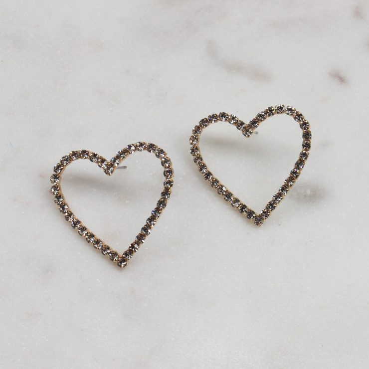 A photo of the Rhinestone Heart Earrings In Gold product