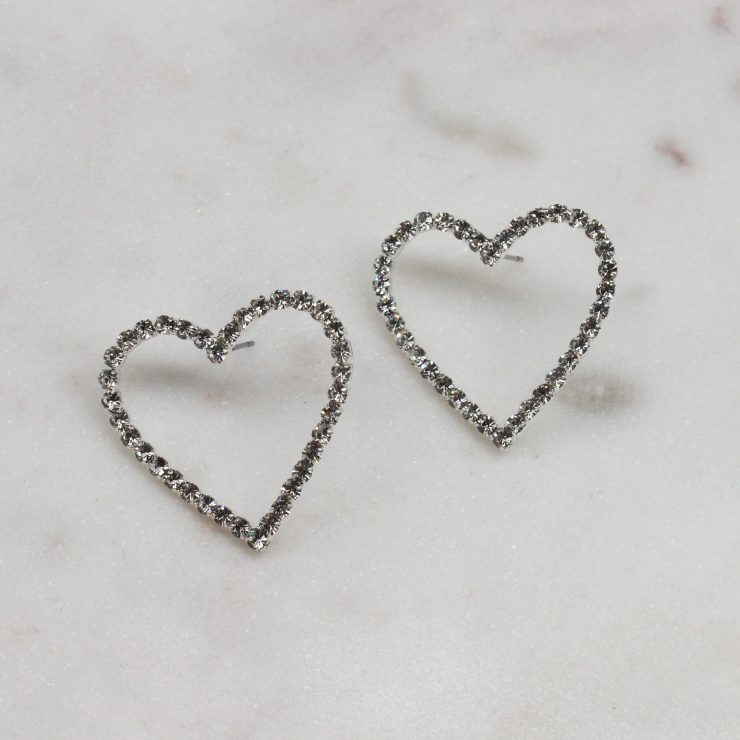 A photo of the Rhinestone Heart Earrings In Silver product