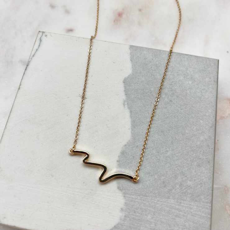 A photo of the Wave Necklace In Gold product