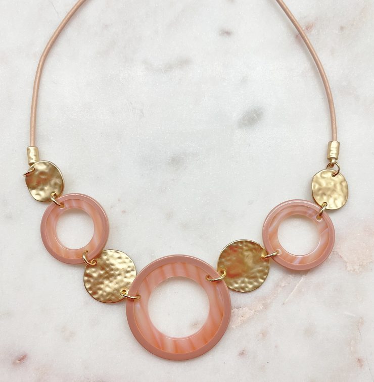 A photo of the Circle Around Necklace In Pink product