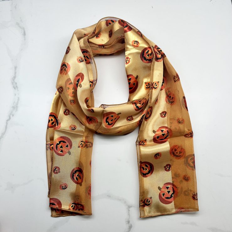 A photo of the Silky Jack-O-Lantern Scarf In Gold product