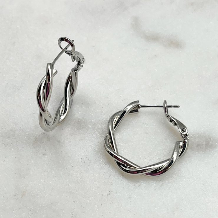 A photo of the Twisted Hoop Earrings In Silver product