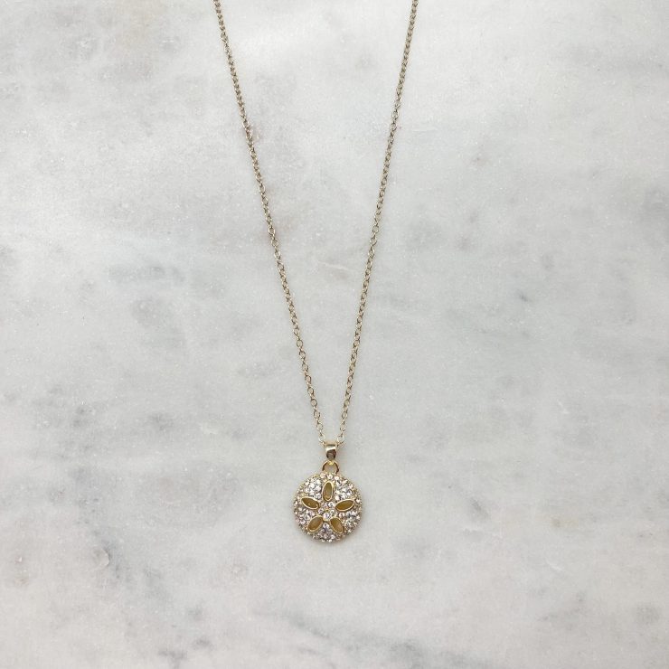 A photo of the Rhinestone Sand Dollar Necklace In Gold product