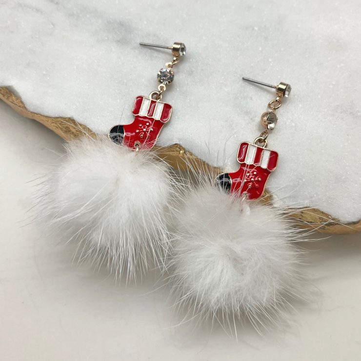 A photo of the Pom Pom Stocking Earrings product