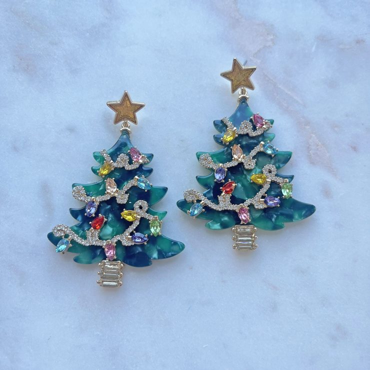 A photo of the Glitzy Christmas Tree Earrings in Green product