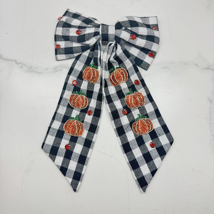 A photo of the Buffalo Check Pumpkin Hair Bow product